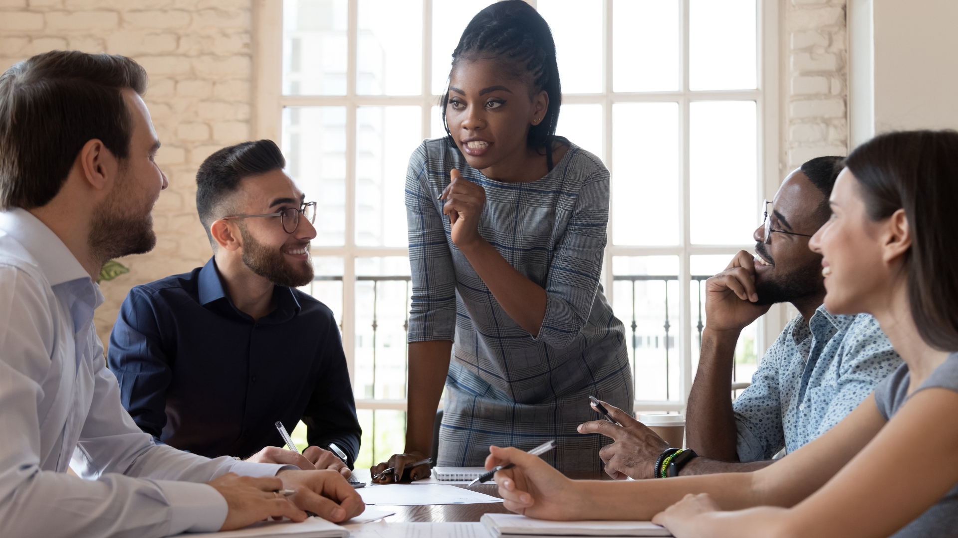 A group of diverse executives sitting around a table discussing a project.