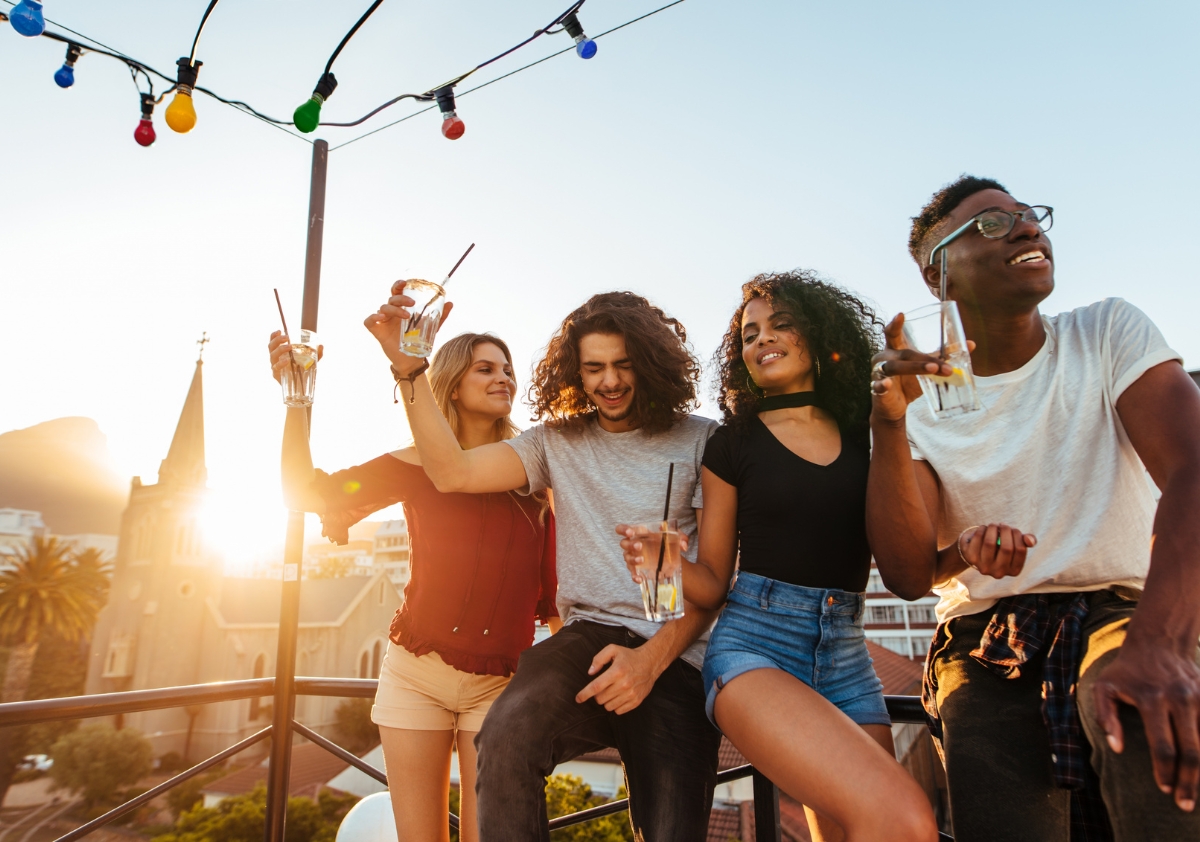 A diverse group of millennials on a patio at sunset showcasing their brand loyalty