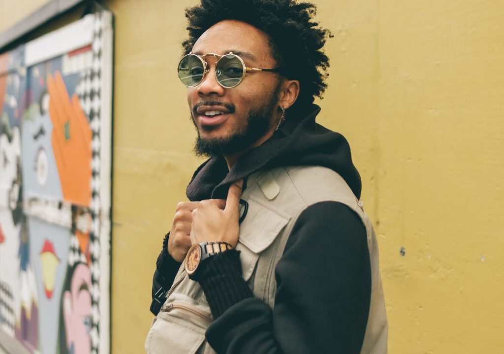 Young African American man with kinky curly fro wearing streetwear fit celebrating Juneteenth via social media engagement