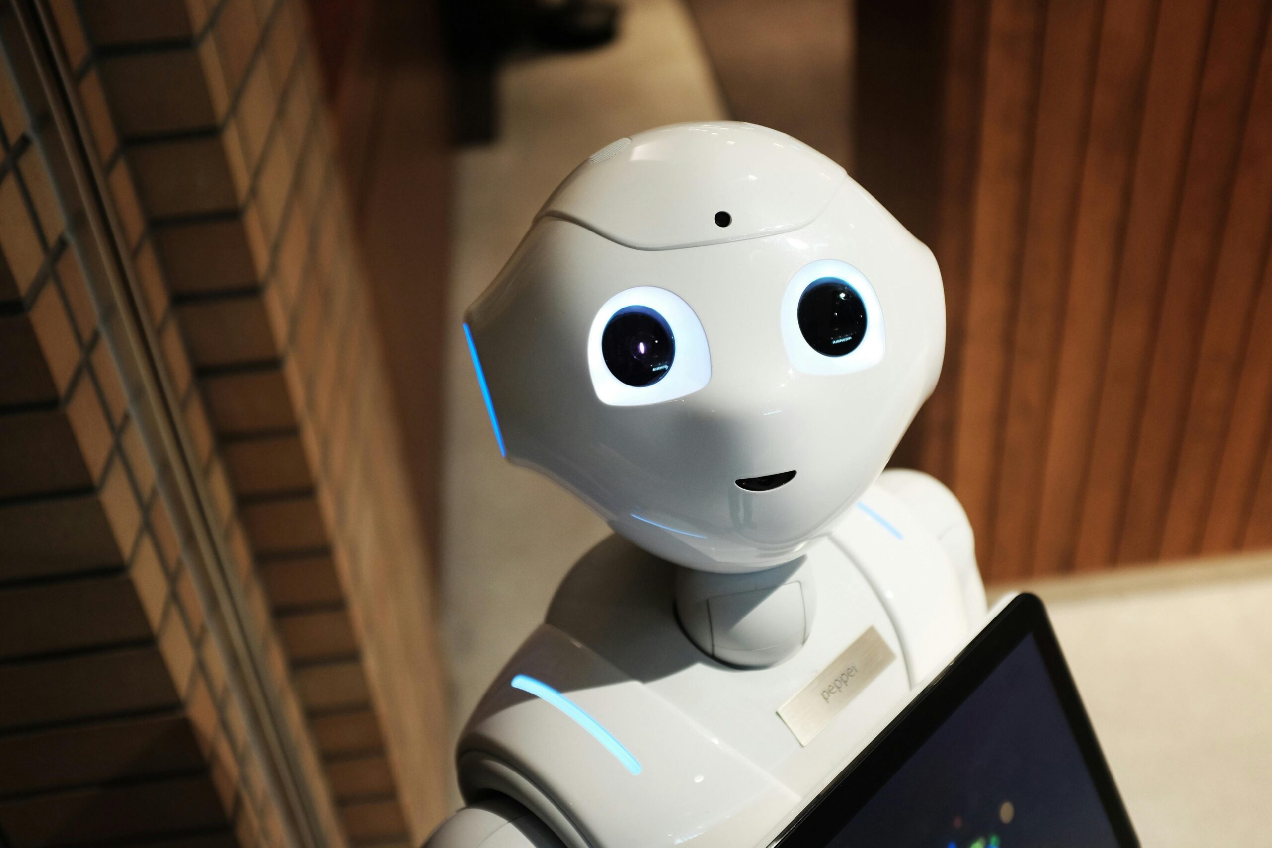 A friendly-looking humanoid robot with a screen, illustrating how AI is transforming media production through interactive technology and automation."